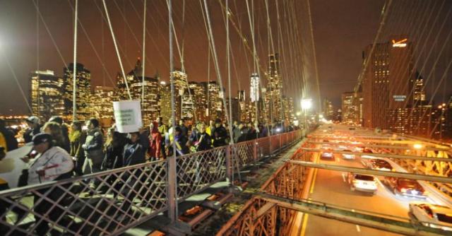Aí, em 18/11/2011, uma marcha em comemoração a DOIS MESES de protestos do Ocupy Wall Street. Os manifestantes seguiram pela Ponte do Brooklyn, em Nova York, em direção a Manhattan. Foto: Henny Ray Abrams/AP