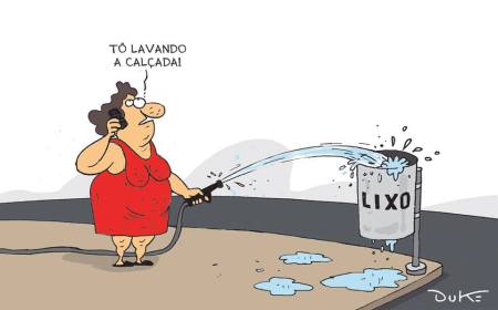 Charge do Duke mostra mulher jogando água de mangueira numa lata de lixo, enquanto diz: "Estou lavando a calçada".