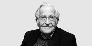 Retrato de Noam Chomsky em preto e branco, sorrindo
