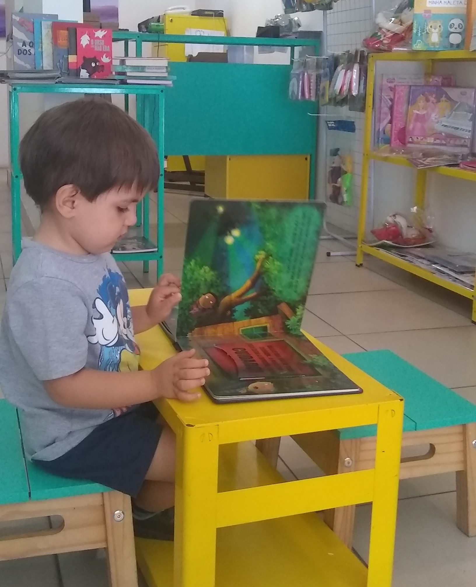 Luiz folheando um livrinho na Colorê!