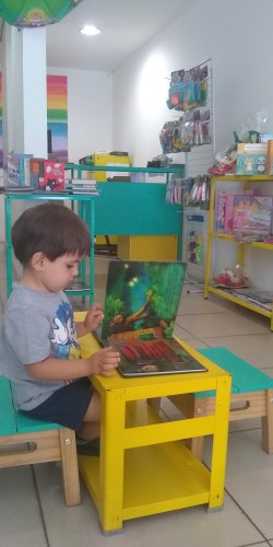 Luiz folheando um livrinho na Colorê!