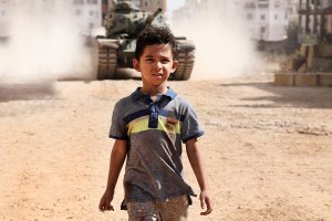 Cena do filme Sementes Podres que mostra o personagem principal quando criança, numa guerra