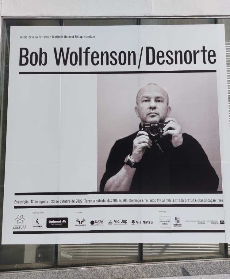 Cartaz da exposição de Bob Wolfenson em BH mostra o fotógrafo com a câmera na mão.
