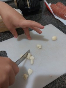 Luiz picando o alho em pedacinhos.