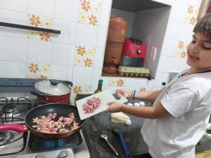 Luiz picou toda a calabresa e colocou na frigideira para refogar com o bacon.