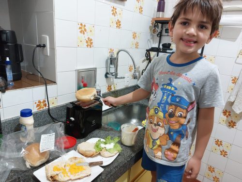 Luiz na "fábrica de fazer hambúrguer". Enquanto eu esquentava as carnes, ele esquentava os pães e montava o sanduíche final.