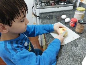 Luiz picando maçã para fazer a panqueca.