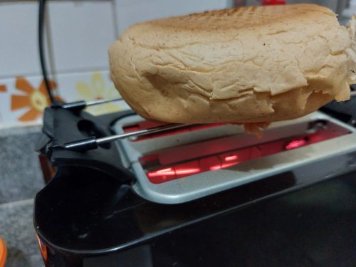 Pão esquentando na torradeira.
