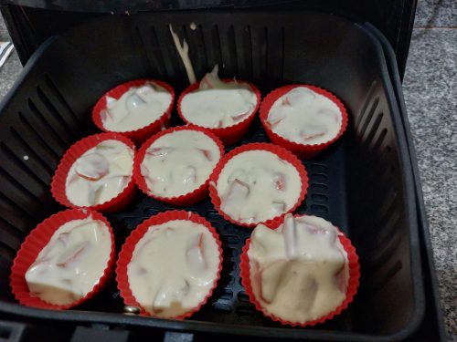 As 9 forminhas de cupcake com a massa de muffin recheado com salsicha, já dentro da airfryer, passar começar a assar.
