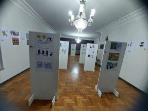 Visão geral da exposição Pra Não Esquecer, que relembra o governo Bolsonaro em charges.