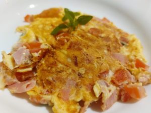 Omelete de tomate, manjericão, queijo e presunto.