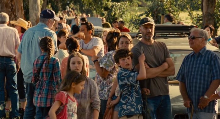 A família Mee da vida real aparece nesta cena do filme 'Compramos um Zoológico': Benjamin é este de boné, seu filho está segurando nele e a filha está ali perto.