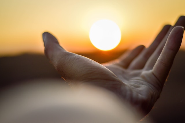 Mão estendida em direção ao sol, em sinal de querer ajudar alguém. Mantra. Decisões e resoluções para o futuro. Anovo novo. Espiritualidade. Foto: Aamir Suhail / Unsplash