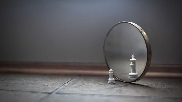 Imagem da vaidade: um peão do xadrez se olha no espelho e enxerga um rei. Não encontrei o crédito desta foto.