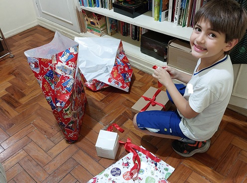 Luiz embrulhando com carinho o presente para o garotinho Davi, da carta que pegamos no Papai Noel dos Correios.
