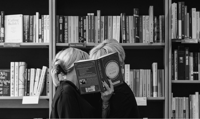 Casal se beijando em uma livraria. Foto: Mira Alex / Unsplash