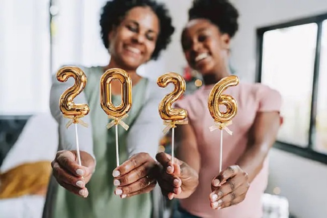 Mães e filha seguram os números "2026", celebrando a chegada do ano novo.