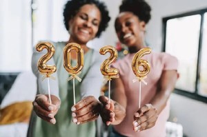 Mães e filha seguram os números "2026", celebrando a chegada do ano novo.