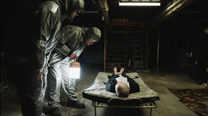 Cena do filme Bugonia, que se concentra em três personagens: Teddy (Jesse Plemons), Don (Aidan Delbis) e Michelle (Emma Stone).