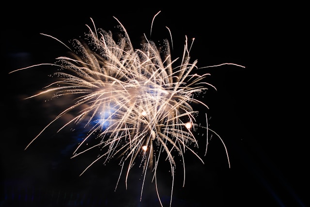Fogos de artifício brilhantes explodem contra um céu noturno escuro. Foto: Jun Ren / Unsplash